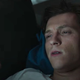 Tom Holland as Peter Parker in Spider-Man: No Way Home, staring at his phone in confusion.